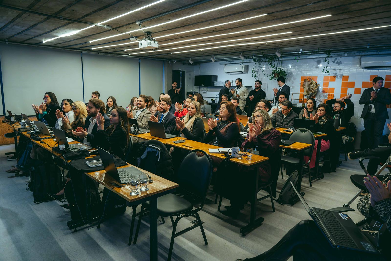 Sala cheia de participantes durante evento da Escola de PI